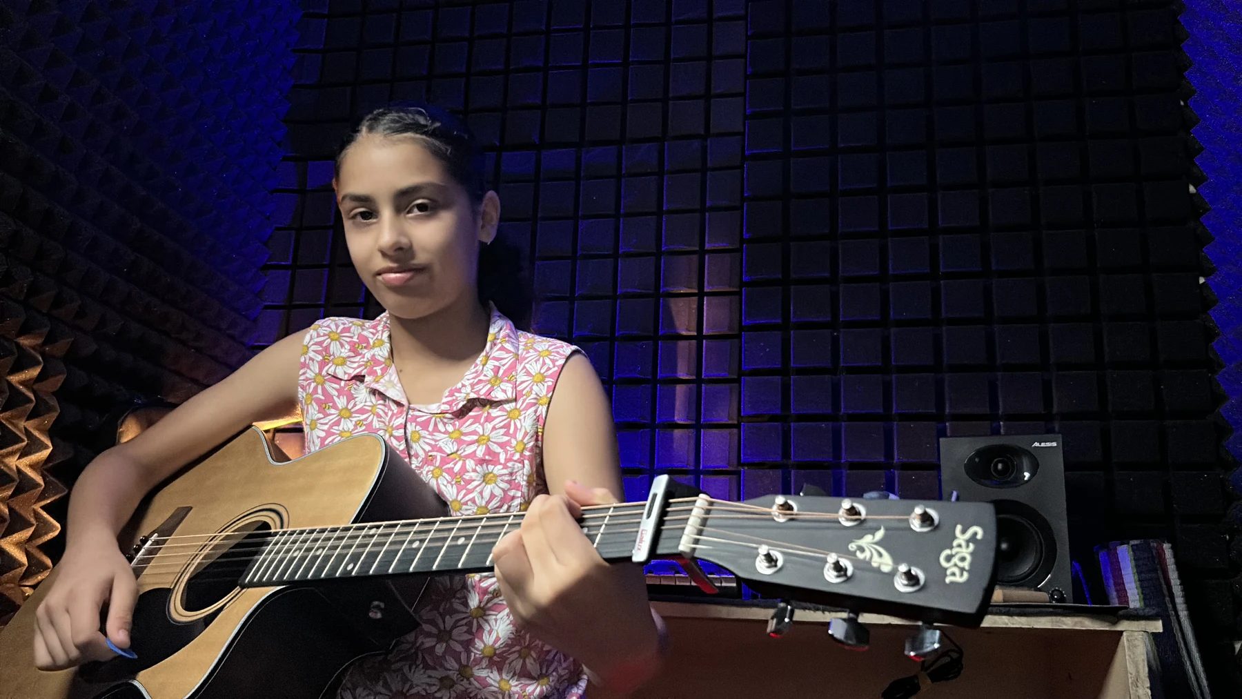 A guitar student inside the school studio