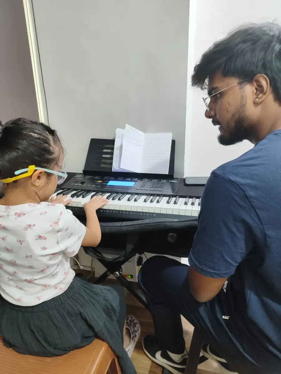 A teacher guiding a young keyboard learner at DSM Dwarka Sector 22