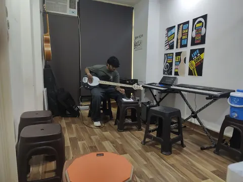 A musician practising a four-string bass in the DSM Dwarka Sector 22 classroom